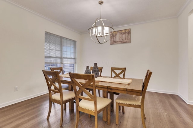 dining room with wood-type flooring, an inviting chandelier, and crown molding