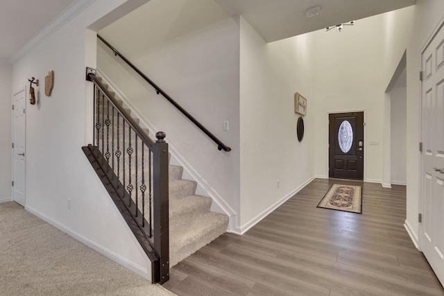 foyer featuring crown molding and light hardwood / wood-style floors