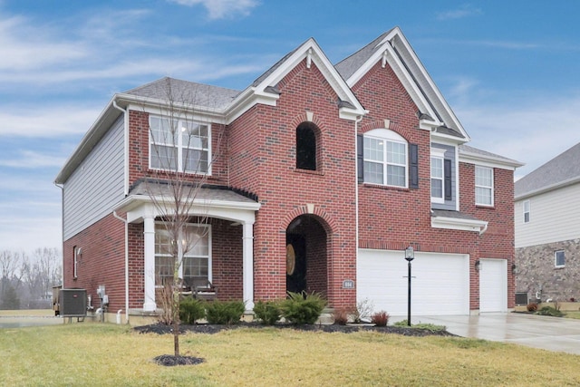 view of front facade with a garage, a front yard, and central air condition unit