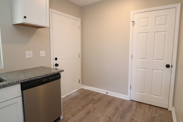 kitchen with white cabinetry, dishwasher, light hardwood / wood-style floors, and dark stone countertops