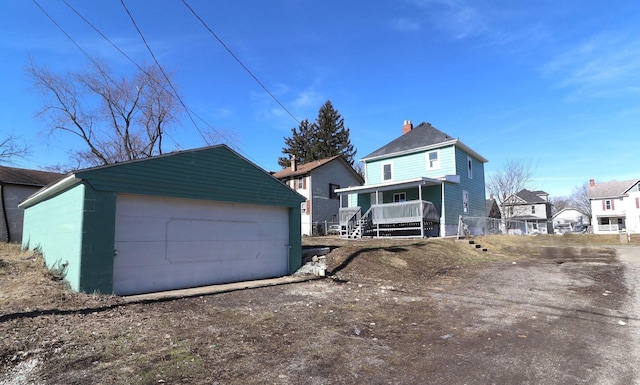 view of front of property featuring a garage, an outdoor structure, and a porch