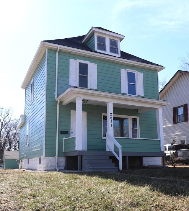 view of front facade with a front yard and covered porch