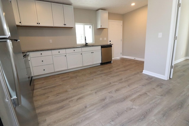 kitchen featuring white cabinetry, stainless steel appliances, sink, and light wood-type flooring