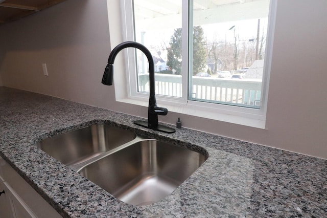 interior details with stone countertops and sink