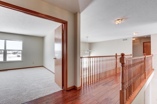 corridor featuring hardwood / wood-style floors and a textured ceiling