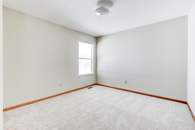 carpeted spare room featuring a textured ceiling