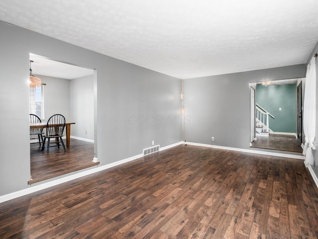 unfurnished room featuring dark hardwood / wood-style flooring and a textured ceiling