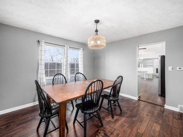 dining room featuring a notable chandelier, a textured ceiling, and dark hardwood / wood-style flooring