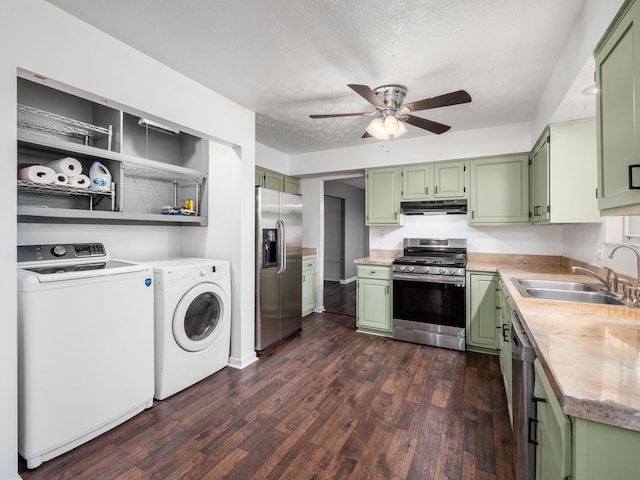 kitchen featuring stainless steel appliances, washer and dryer, and green cabinetry