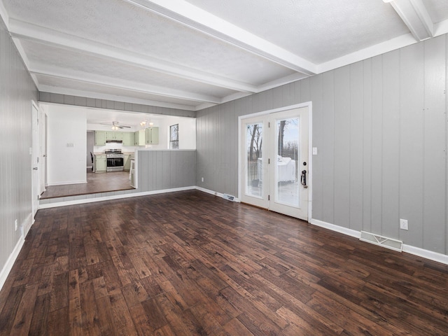 unfurnished living room featuring ceiling fan, dark hardwood / wood-style floors, and beamed ceiling