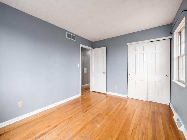 unfurnished bedroom featuring light hardwood / wood-style floors and a closet