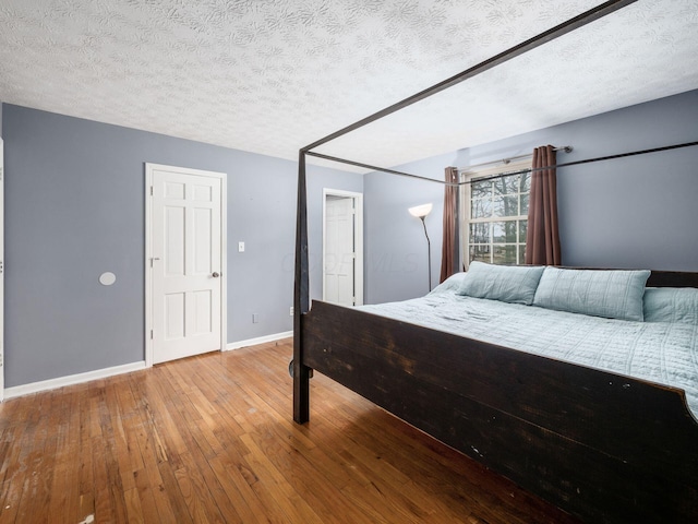 bedroom featuring hardwood / wood-style floors and a textured ceiling