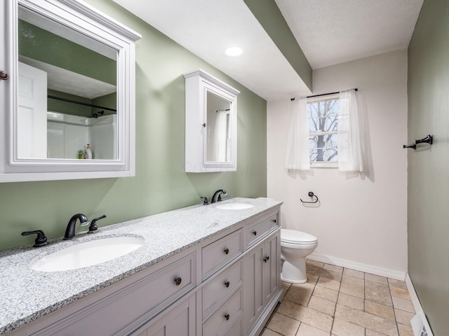 bathroom with vanity, toilet, and a textured ceiling