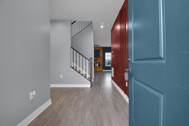 foyer entrance with wood walls and light hardwood / wood-style flooring