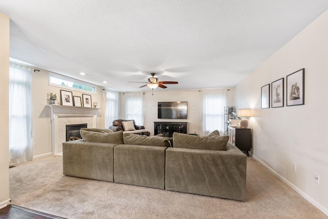 carpeted living room featuring a textured ceiling and ceiling fan