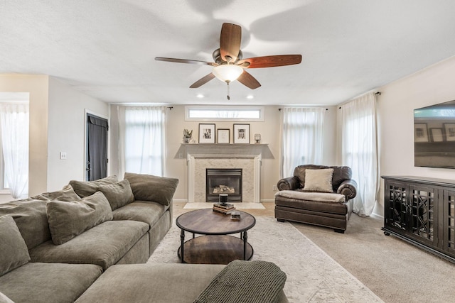 living room with ceiling fan, light carpet, and a high end fireplace