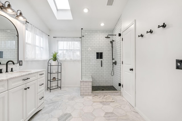 bathroom featuring lofted ceiling with skylight, vanity, and walk in shower