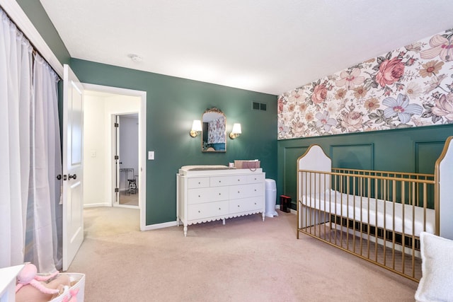 bedroom featuring a crib and light carpet