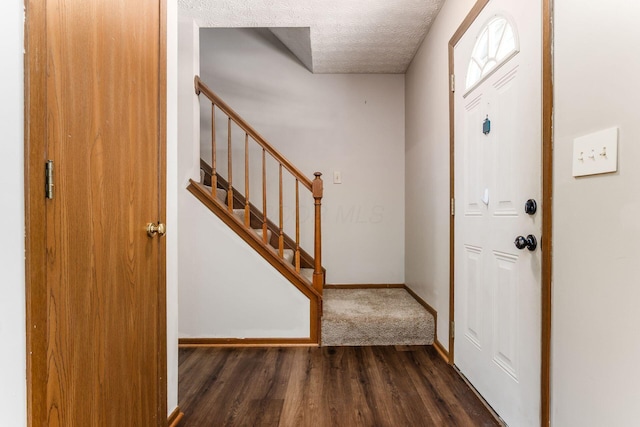 entrance foyer featuring a textured ceiling and dark hardwood / wood-style flooring