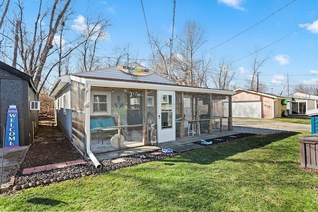 13983 Custers Point Rd NE, Thornville, OH 43076 - view of front facade with a garage, driveway, a sunroom, an outbuilding, and a front lawn