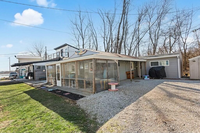 rear view of property with a sunroom and a lawn