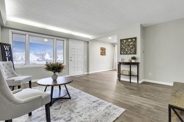 sitting room with hardwood / wood-style floors and a textured ceiling