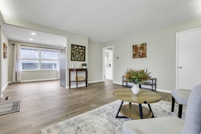 living room with wood-type flooring and a textured ceiling