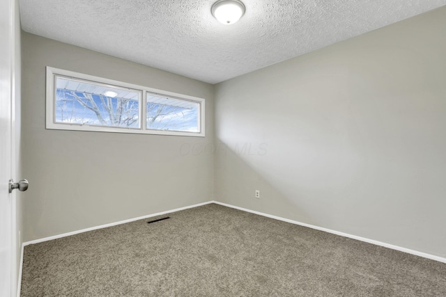 carpeted empty room with a textured ceiling