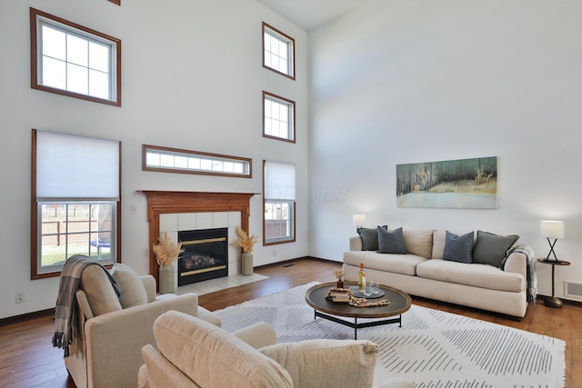 living room featuring a wealth of natural light, a fireplace, and light hardwood / wood-style floors