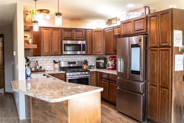 kitchen featuring appliances with stainless steel finishes, decorative light fixtures, sink, and decorative backsplash