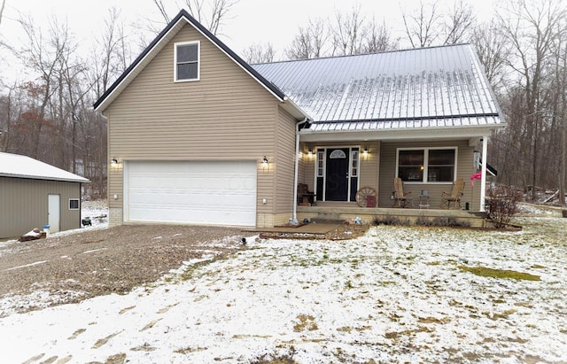 view of front of home with covered porch, metal roof, and a garage