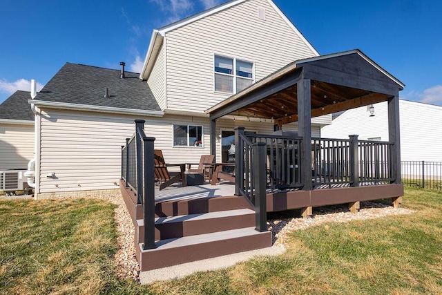 back of property with a wooden deck, central AC, and a lawn