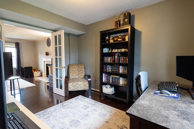 home office with a textured ceiling, dark hardwood / wood-style flooring, and french doors