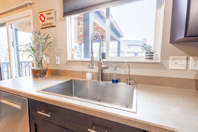 kitchen with sink, stainless steel dishwasher, and dark brown cabinetry