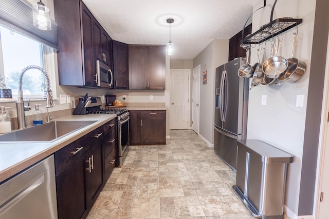 kitchen with sink, decorative light fixtures, dark brown cabinets, and stainless steel appliances