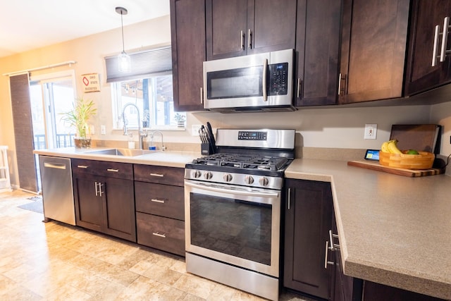 kitchen featuring stainless steel appliances, decorative light fixtures, sink, and dark brown cabinets