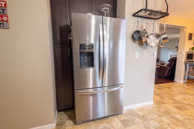 kitchen featuring dark brown cabinets and stainless steel fridge