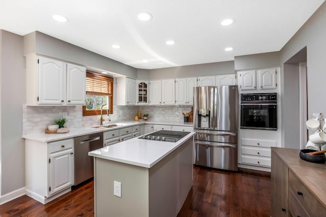 kitchen featuring decorative backsplash, dark wood-style floors, a sink, and black appliances