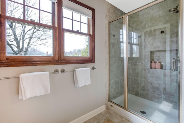 bathroom with baseboards, tile patterned flooring, and a stall shower