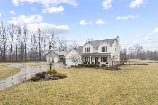 view of front of house featuring covered porch, a front lawn, and a garage