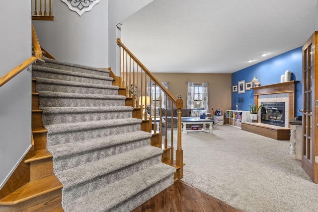 stairway featuring hardwood / wood-style flooring and a tiled fireplace