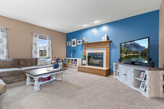 living room with light colored carpet and a tiled fireplace