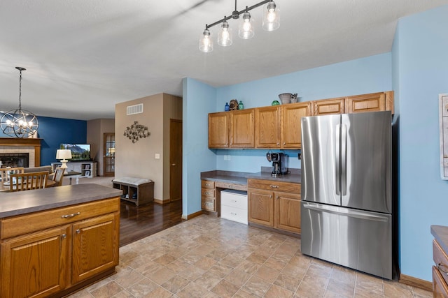 kitchen with stainless steel refrigerator, hanging light fixtures, and an inviting chandelier