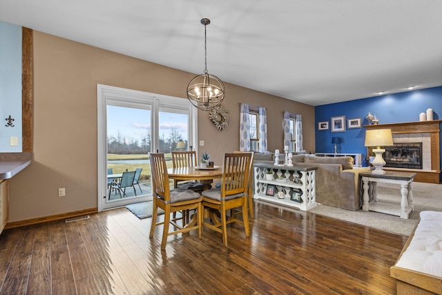 dining room with dark wood-type flooring and a chandelier