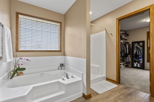 bathroom featuring hardwood / wood-style flooring and plus walk in shower