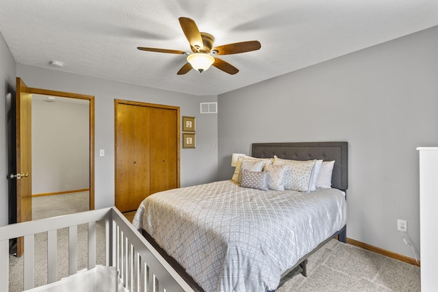 carpeted bedroom with ceiling fan and a textured ceiling