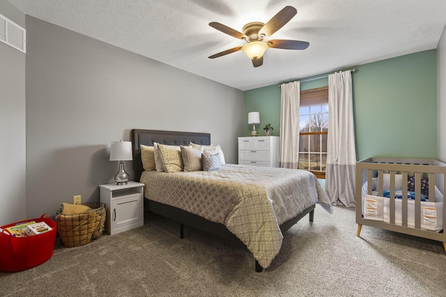 carpeted bedroom featuring a textured ceiling and ceiling fan