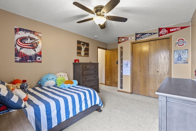 bedroom featuring ceiling fan, carpet floors, a textured ceiling, and a closet