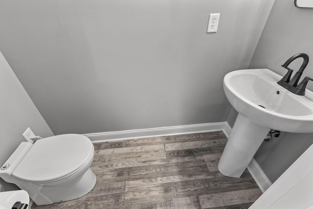 bathroom with toilet and wood-type flooring