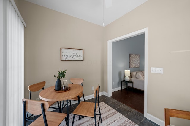 dining area with dark tile patterned floors and baseboards